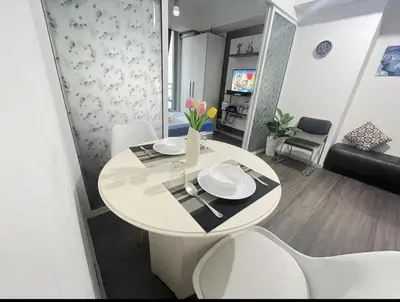 a dining table and chairs in a living room at Azure Urban Resort with WIFI and Netflix in Manila