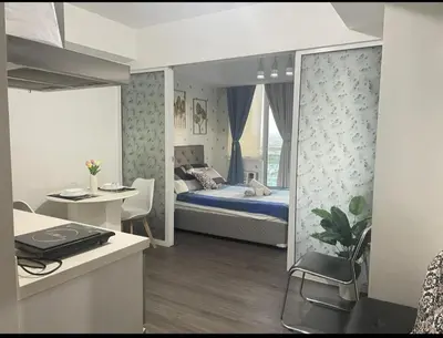 a bedroom with a bed and a desk and a table at Azure Urban Resort with WIFI and Netflix in Manila