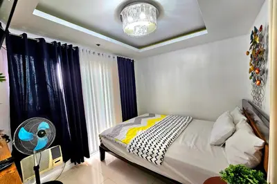a bedroom with a bed and a fan at Birchtower by Jeizel Manila City in Manila