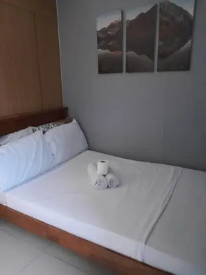 a white bed with two rolls of towels on it at Shell Residences C15 Shortwalk Sm Mall Of Asia/Airport in Manila
