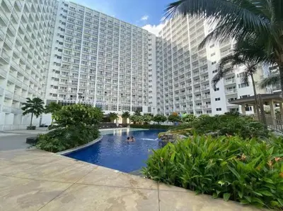 a large building with a swimming pool in front of it at Shore Residence D11 Shortwalk Mall Of Asia/ In't Airport in Manila