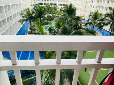 a balcony with a view of a pool and palm trees at Shore Residence D11 Shortwalk Mall Of Asia/ In't Airport in Manila