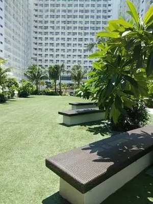 a park with benches in front of a large building at Shore Residence D11 Shortwalk Mall Of Asia/ In't Airport in Manila