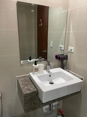 a bathroom with a white sink and a mirror at One Uptown Residence BGC in Manila