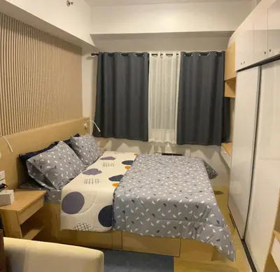 a small bedroom with a bed and black curtains at SEA Residences in Pasay near Mall of Asia in Manila