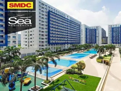 a view of a large building with a swimming pool at SEA Residences in Pasay near Mall of Asia in Manila