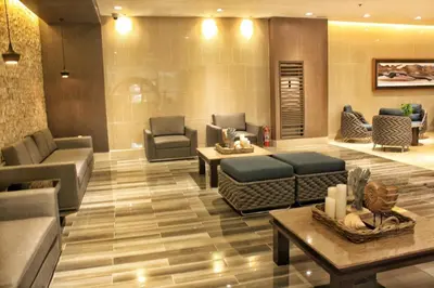 a living room with couches and tables in a building at Shore Residences MOA Staycation in Manila