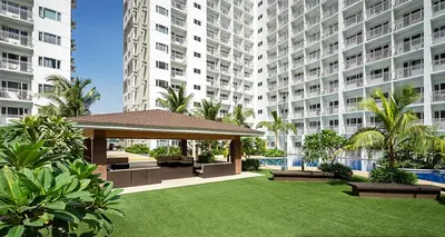 a garden with a gazebo in front of a large building at Shore Residences MOA Staycation in Manila