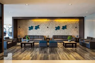 a lobby with couches and tables and a stone wall at Shore Residences MOA Staycation in Manila