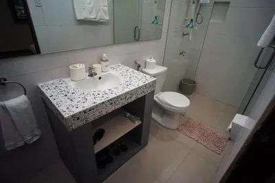 a bathroom with a sink and a toilet and a shower at Tagaytay Foothills Cherimoya Farm Staycation in Biboyan