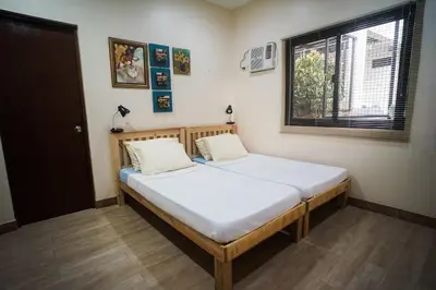 a bedroom with a bed in a room with a window at Tagaytay Foothills Cherimoya Farm Staycation in Biboyan