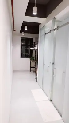 a corridor of an office with white walls and doors at The Grid Co-Living Managed by HII in Manila