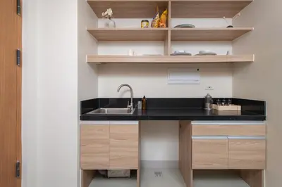 a kitchen with a sink and wooden shelves at The Grid Co-Living Managed by HII in Manila