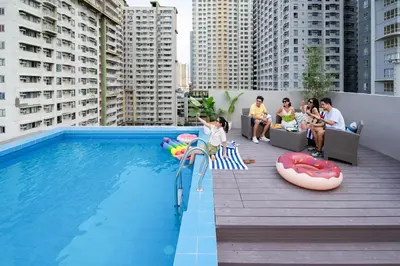 a group of people sitting around a swimming pool at The Grid Co-Living Managed by HII in Manila