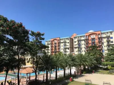 a resort with a pool and palm trees and buildings at CHATEAU ELYSEE A11 Near Sm Mall and Airport in Manila