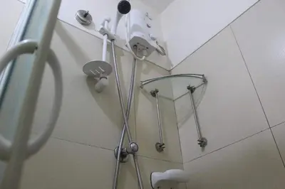 a shower in a bathroom with a shower head at CHATEAU ELYSEE A11 Near Sm Mall and Airport in Manila