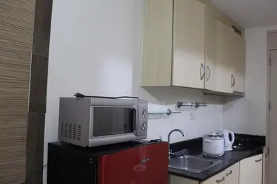 a kitchen with a microwave on top of a refrigerator at CHATEAU ELYSEE A11 Near Sm Mall and Airport in Manila