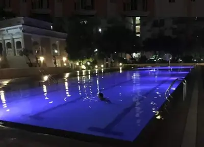 a large swimming pool with blue lighting at night at CHATEAU ELYSEE A13 Near Resto And Sm Mall/Airport in Manila