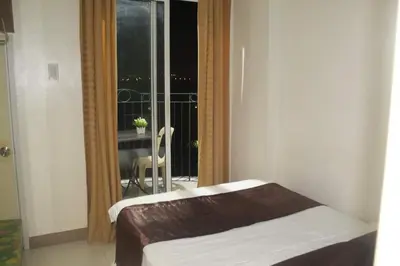 a bed in a room with a view of a balcony at CHATEAU ELYSEE A1 near airport mall Free wifi in Manila