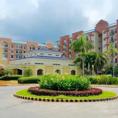 a large yellow building with palm trees in front of it at CHATEAU ELYSEE A1 near airport mall Free wifi in Manila