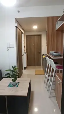 a kitchen and living room with a table and chairs at Cozy 1Br with Netflix & Balcony Pool View Condo in Manila