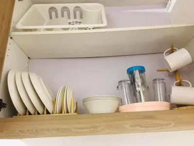 a shelf with plates and other kitchen utensils at Shore Residence Staycation unit at Mall of Asia in Manila