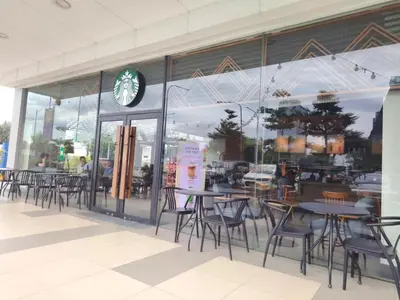 a restaurant with tables and chairs in front of a window at Shore Residence Staycation unit at Mall of Asia in Manila