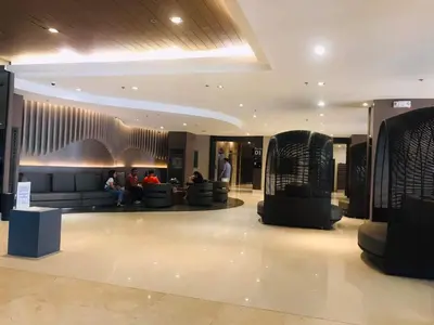 a lobby with people sitting on couches in a building at Condo- tel for At Mall of Asia Philippines in Manila