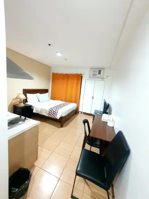 a hotel room with a bed and a table and chairs at Sab R. Bel air soho in Manila