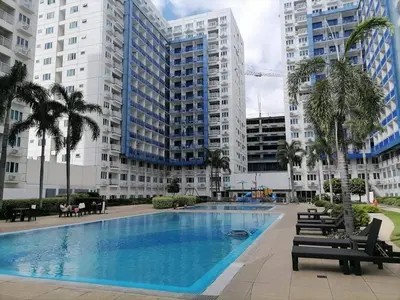 a large swimming pool in front of a large building at The FINEST Sea Residences Condo in Manila