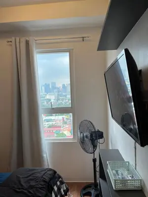 a bedroom with a desk with a computer and a window at The Cozy Place Condo in Pasig Phil in Manila
