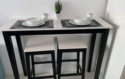 a black and white table with two plates and stools at Comfy Condo Grand Riviera Suite, Roxas Blvd Ermita Manila infront of US Embassy in Manila