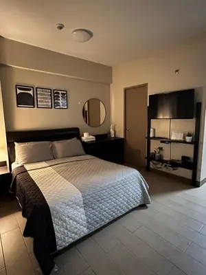 a bedroom with a large bed and a mirror at Cozy condo near Airport Manila in Manila