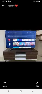 a flat screen tv sitting on top of a wooden stand at VICTORIA DE MAKATI Two (2) Bedroom Up and Down Condo in Manila