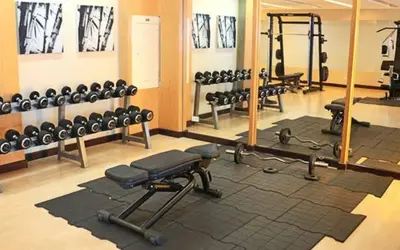 a gym with a lot of equipment and a mirror at Relaxing Big Studio Bedroom in Manila