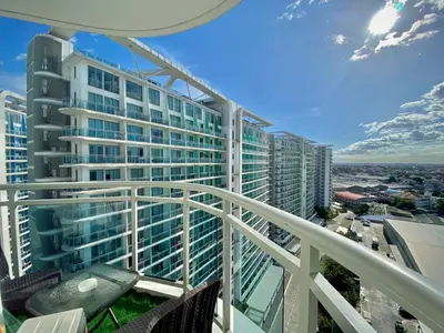 a balcony with a view of a large building at The Cozy-Corner Staycation at the Azure Urban Resort Residences in Manila