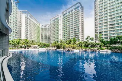 a large swimming pool in front of tall buildings at The Cozy-Corner Staycation at the Azure Urban Resort Residences in Manila