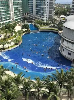a large swimming pool in a city with people in it at The Cozy-Corner Staycation at the Azure Urban Resort Residences in Manila