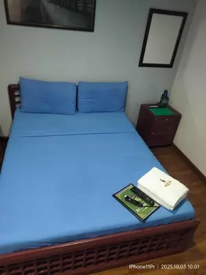 a bed with blue sheets and a book on it at duck inn manila in Manila