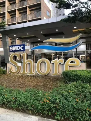 a sign in front of a building with a surfboard at 1 Bedroom lovely place near Mall of Asia in Manila