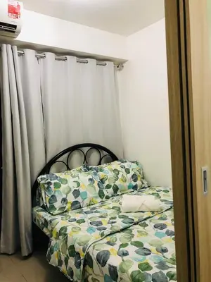 a small bedroom with a bed with a curtain at 1 Bedroom lovely place near Mall of Asia in Manila