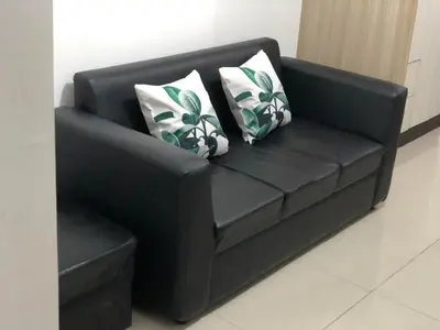 a black leather couch with two pillows on it at 1 Bedroom lovely place near Mall of Asia in Manila
