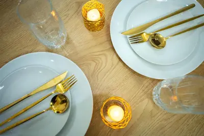 two plates with forks and knives and candles on a table at Elite Pod at Knightsbridge Residences Makati in Manila