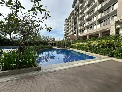 a swimming pool in front of a building at Alea Residences in Manila