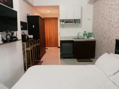 a room with a kitchen and a bed in it at Grand riviera suites Studio Type Only in Manila