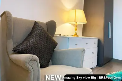 a couch with a pillow and a lamp next to a dresser at Century Spire Makati in Manila