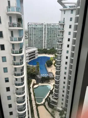 a view of a swimming pool between two buildings at The Carribean Suites by Azure in Manila