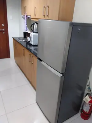 a kitchen with a black and white refrigerator at Condo at Shell Residences in Manila