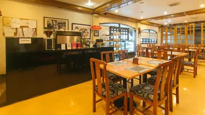 a restaurant with wooden tables and chairs and a bar at Aloha Hotel Roxas Boulevard Manila in Manila