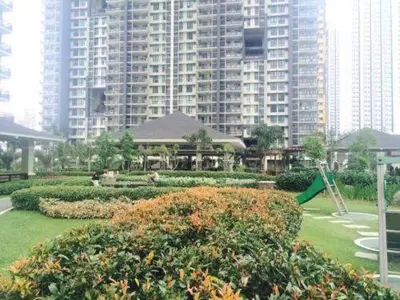 a park with a playground and a large building at Bunked Bed Room Sharing in Manila